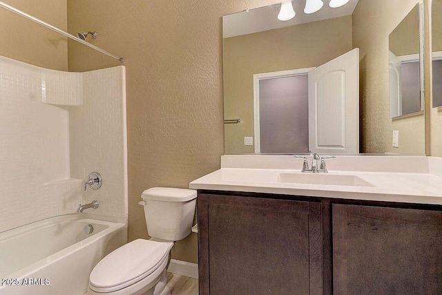 full bath featuring shower / washtub combination, a textured wall, vanity, and toilet