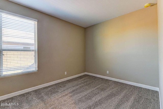 empty room with carpet and baseboards