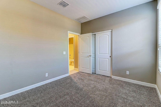 unfurnished bedroom featuring carpet floors, visible vents, and baseboards