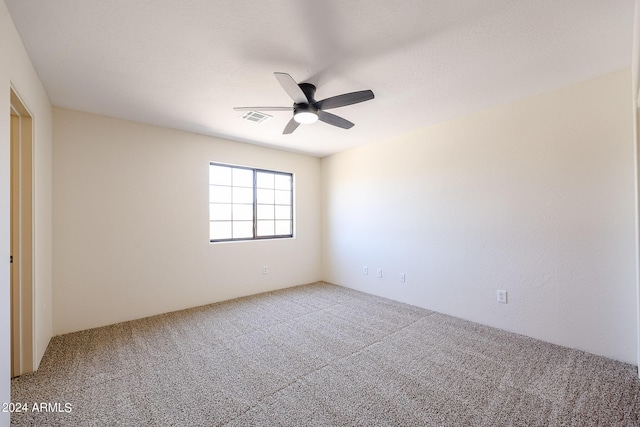 carpeted spare room featuring ceiling fan