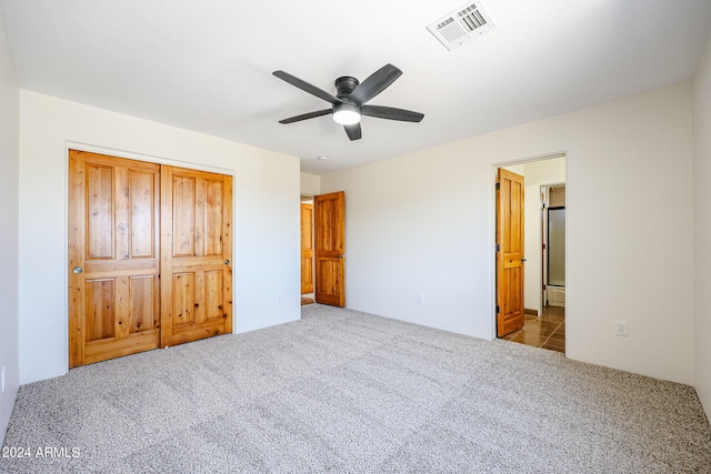 unfurnished bedroom with stainless steel refrigerator, light carpet, and ceiling fan