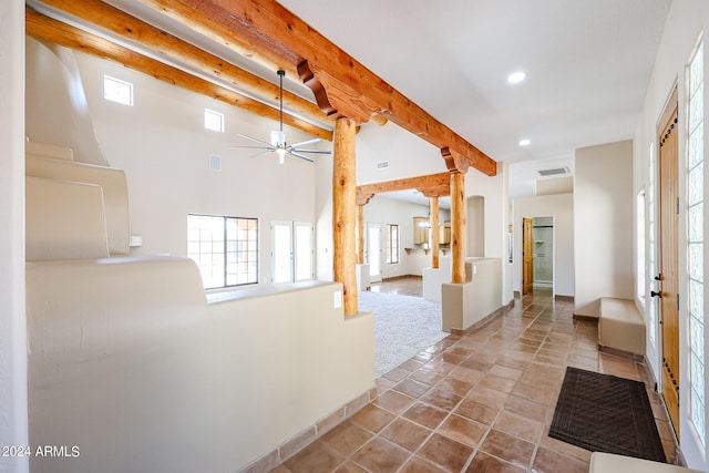 hallway with light tile patterned floors, decorative columns, and beamed ceiling