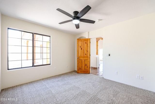 carpeted spare room with ceiling fan