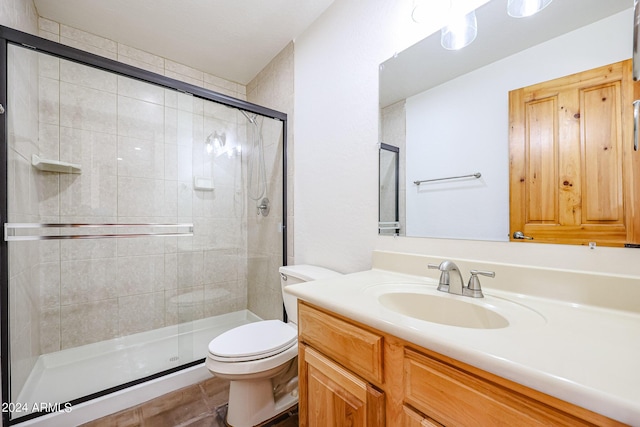 bathroom with vanity, toilet, and a shower with shower door