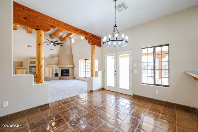 interior space with beamed ceiling, a tiled fireplace, a wealth of natural light, and high vaulted ceiling