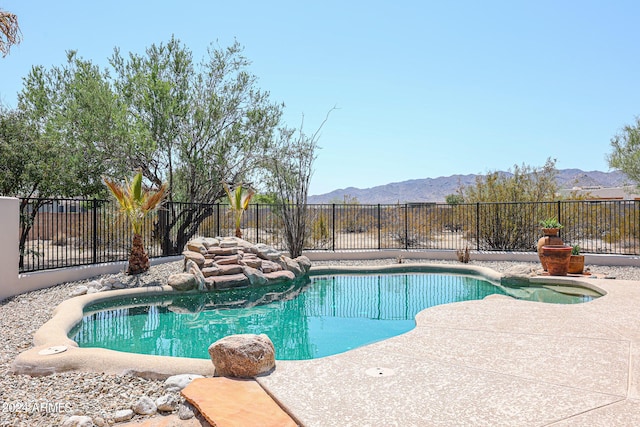 view of swimming pool with a mountain view and a patio area