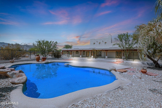 pool at dusk featuring a patio