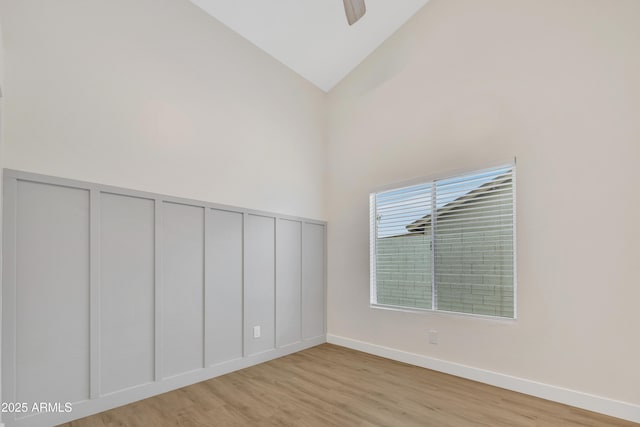 7685 W San Miguel Ave, Glendale, AZ 85303 - unfurnished room featuring wood finished floors, a decorative wall, high vaulted ceiling, a ceiling fan, and wainscoting
