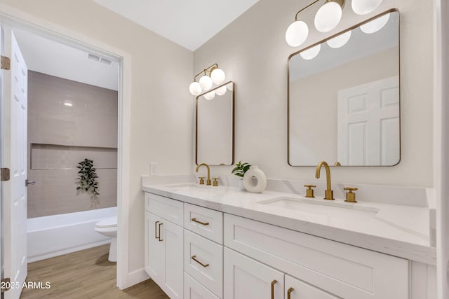 7685 W San Miguel Ave, Glendale, AZ 85303 - full bathroom featuring double vanity, wood finished floors, and washtub / shower combination
