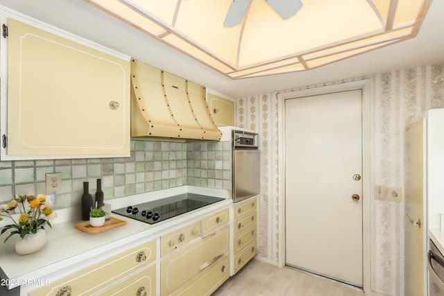 kitchen featuring black electric stovetop, light tile patterned floors, ceiling fan, decorative backsplash, and ventilation hood