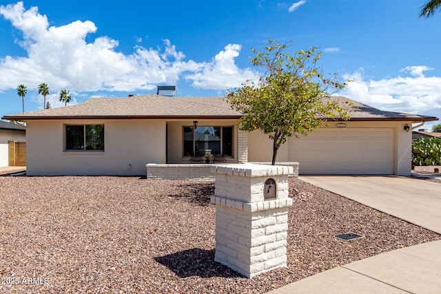 single story home featuring a garage, driveway, and a shingled roof