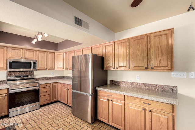 kitchen with ceiling fan, brick patterned floor, visible vents, stainless steel appliances, and light brown cabinets