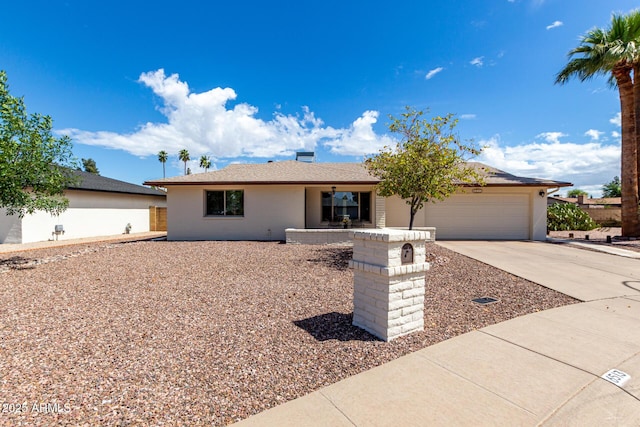 ranch-style house featuring concrete driveway and an attached garage