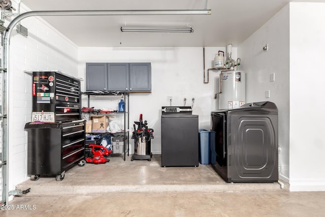 laundry room featuring water heater, washing machine and clothes dryer, a garage, and laundry area