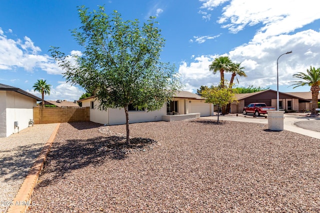 exterior space with an attached garage, stucco siding, and fence
