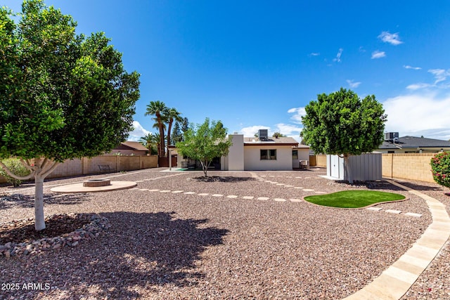 view of yard with an outdoor fire pit, an outdoor structure, a fenced backyard, and a patio area