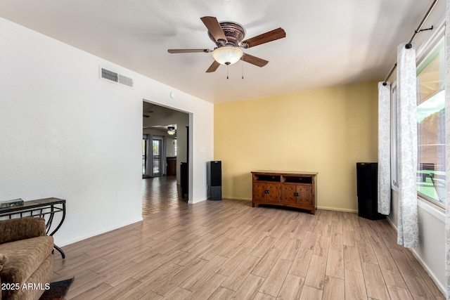 unfurnished room with light wood-style floors, visible vents, a ceiling fan, and a healthy amount of sunlight
