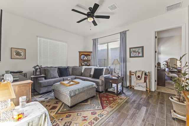 living area featuring visible vents, dark wood-type flooring, and ceiling fan