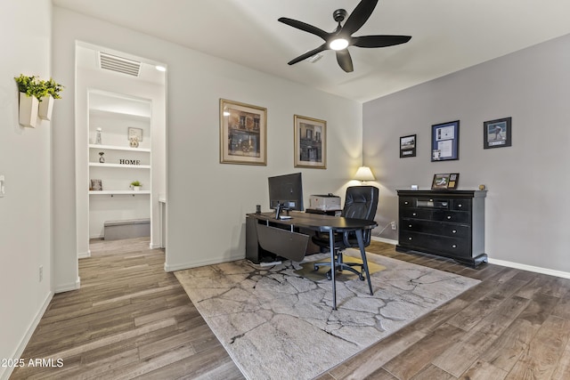 office with visible vents, baseboards, wood finished floors, and a ceiling fan