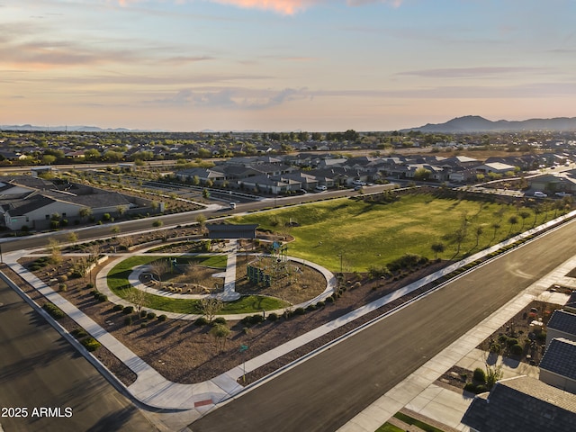 aerial view at dusk featuring a mountain view and a residential view