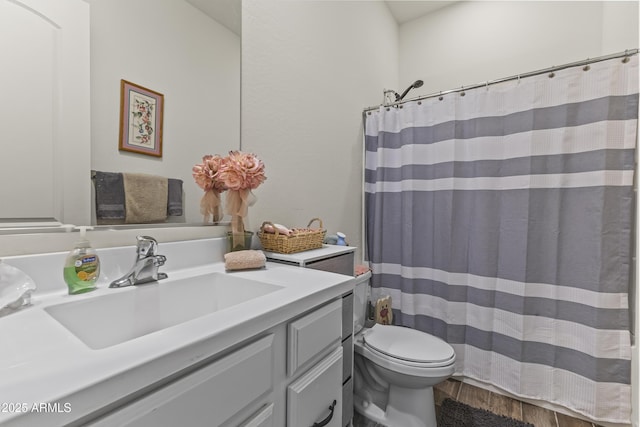 bathroom with vanity, a shower with curtain, toilet, and wood finished floors