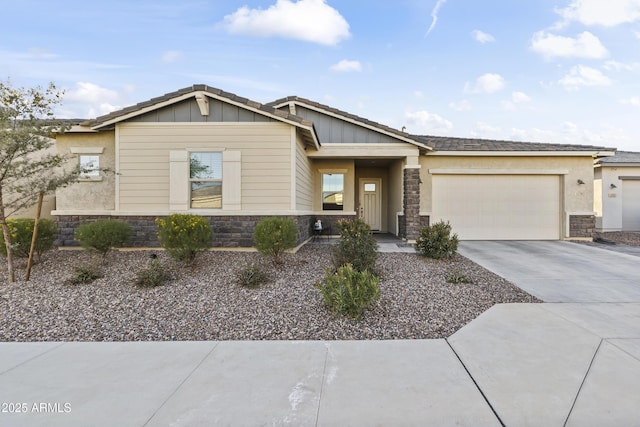 view of front of house featuring a garage, stone siding, board and batten siding, and concrete driveway