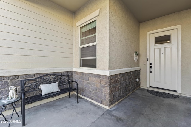 doorway to property with stone siding and stucco siding