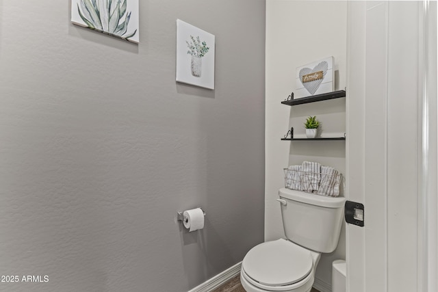 bathroom with toilet and baseboards