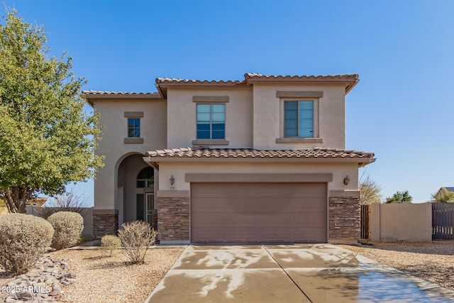 mediterranean / spanish-style house with a tiled roof, a garage, stone siding, and stucco siding