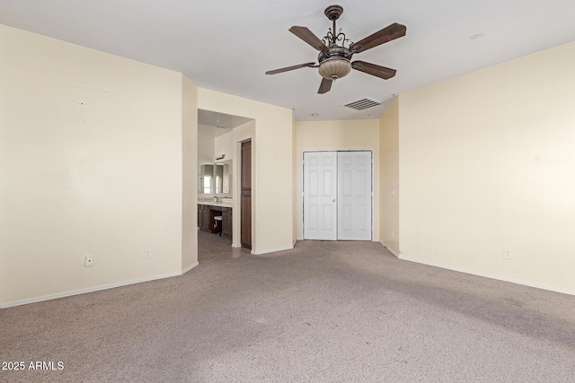 empty room featuring visible vents, ceiling fan, baseboards, and carpet