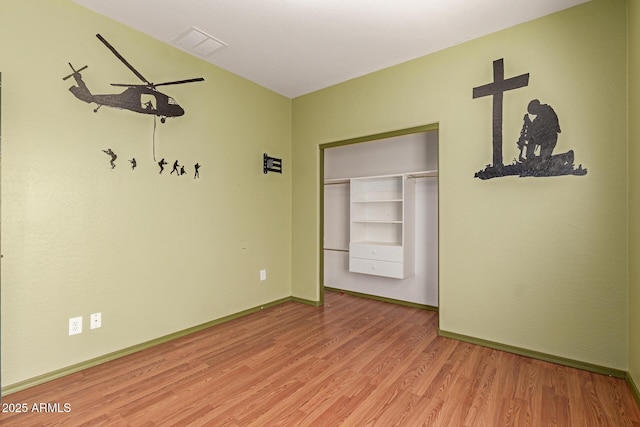 unfurnished room with visible vents, light wood-type flooring, and baseboards