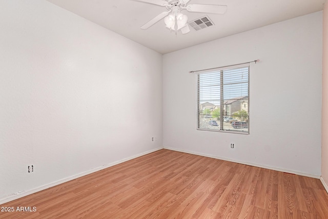 empty room featuring visible vents, light wood-style flooring, baseboards, and ceiling fan