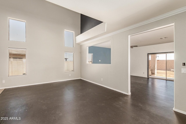 unfurnished living room with visible vents, baseboards, ornamental molding, a towering ceiling, and concrete flooring