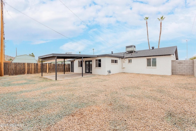 back of property with central AC and a patio area