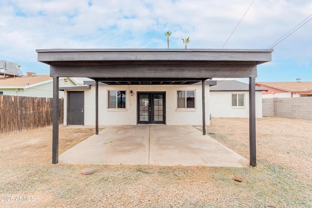 rear view of property with a patio area, central AC unit, and french doors