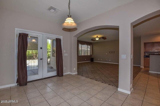 entryway with ceiling fan, light tile patterned floors, and french doors