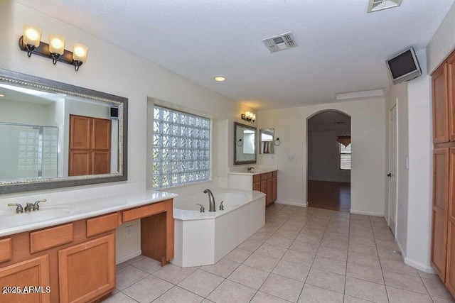 bathroom with vanity, tile patterned flooring, and plus walk in shower