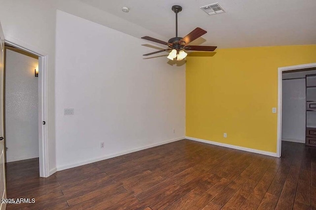 empty room featuring ceiling fan, vaulted ceiling, and dark hardwood / wood-style floors