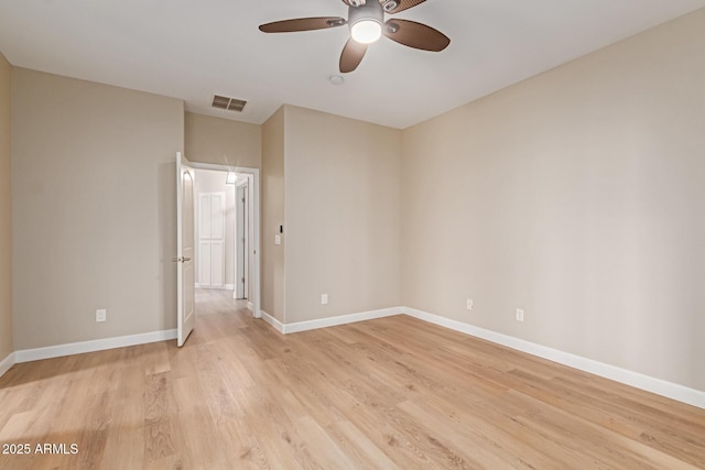 empty room featuring light wood-style floors, baseboards, visible vents, and ceiling fan