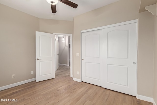 unfurnished bedroom with light wood-type flooring, baseboards, and a closet