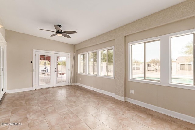 unfurnished sunroom featuring ceiling fan and french doors