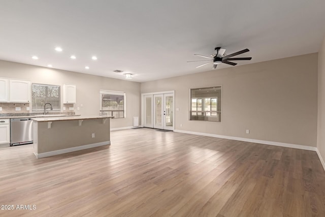 unfurnished living room with light wood-style flooring, recessed lighting, a ceiling fan, baseboards, and french doors