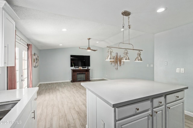 8051 W Mariposa Dr, Phoenix, AZ 85033 - kitchen with baseboards, light wood-type flooring, lofted ceiling, a ceiling fan, and light countertops