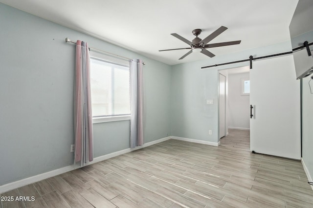 8051 W Mariposa Dr, Phoenix, AZ 85033 - spare room featuring a barn door, a ceiling fan, plenty of natural light, and wood finished floors