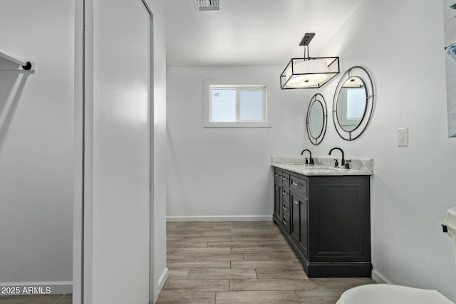 8051 W Mariposa Dr, Phoenix, AZ 85033 - bathroom with vanity, toilet, baseboards, and wood finished floors