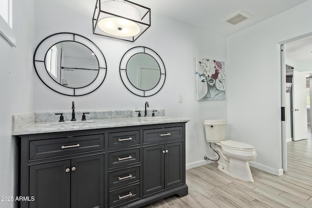 8051 W Mariposa Dr, Phoenix, AZ 85033 - full bathroom with baseboards, double vanity, toilet, and wood finished floors