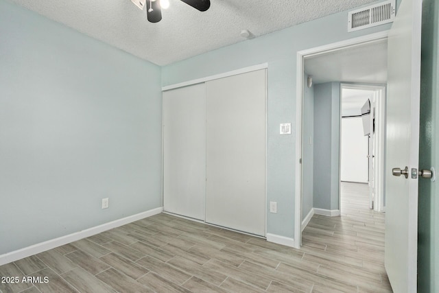 8051 W Mariposa Dr, Phoenix, AZ 85033 - unfurnished bedroom featuring wood finished floors, baseboards, a closet, a textured ceiling, and a ceiling fan