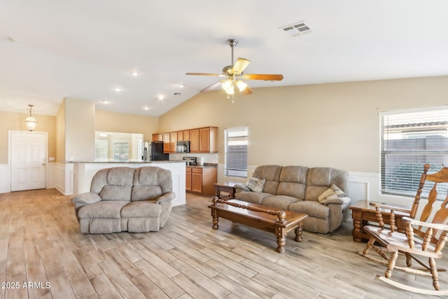 living room with a healthy amount of sunlight, ceiling fan, light hardwood / wood-style flooring, and lofted ceiling