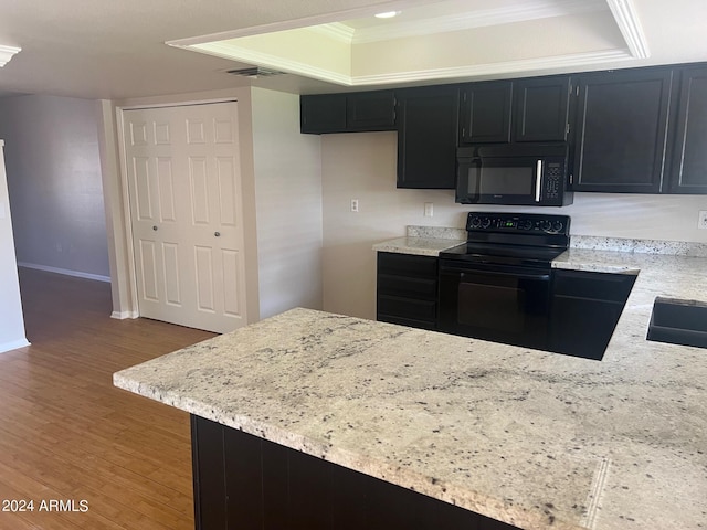 kitchen with crown molding, light stone counters, wood-type flooring, black appliances, and kitchen peninsula