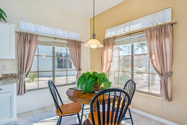 dining space with a healthy amount of sunlight, baseboards, and light tile patterned flooring